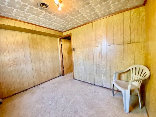 unfurnished room featuring wooden walls