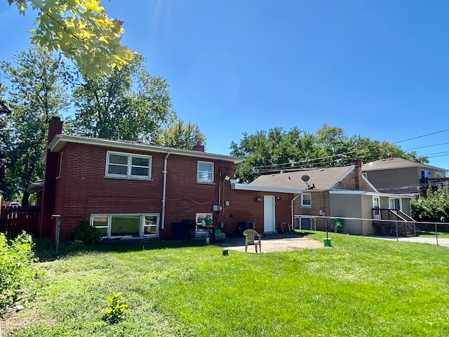 rear view of house with a lawn and a patio