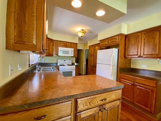 kitchen featuring sink, dark hardwood / wood-style floors, and white appliances