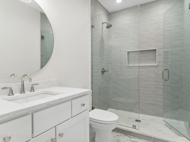 bathroom featuring toilet, a shower with door, and vanity