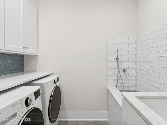 clothes washing area with tile patterned flooring, independent washer and dryer, and cabinets