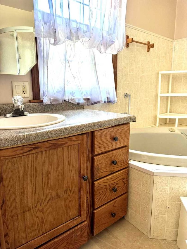 bathroom featuring tile patterned floors, tiled bath, and vanity