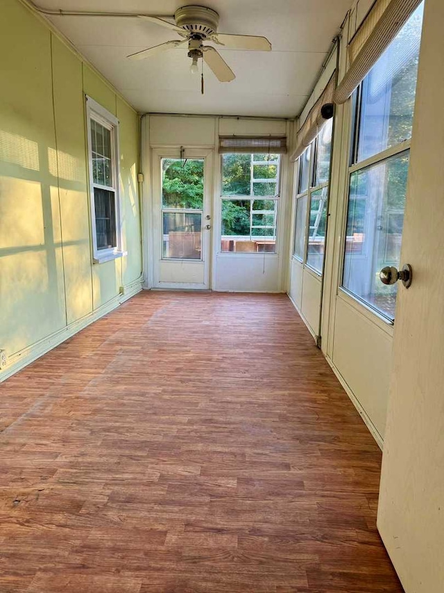 unfurnished sunroom featuring ceiling fan