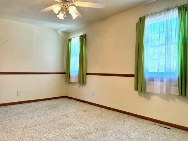 carpeted empty room featuring ceiling fan