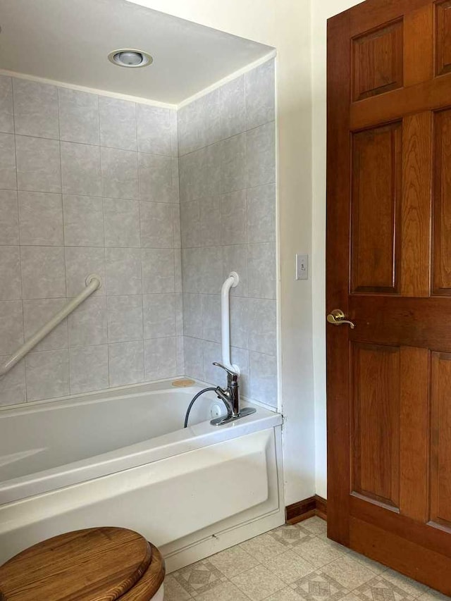 bathroom featuring a bath, tile patterned flooring, and toilet