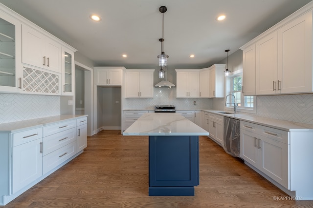 kitchen featuring backsplash, a kitchen island, pendant lighting, and light hardwood / wood-style floors