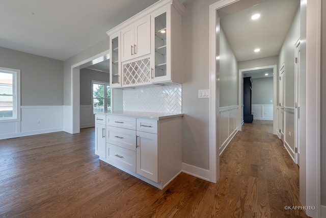 kitchen featuring white cabinetry, dark hardwood / wood-style flooring, and tasteful backsplash