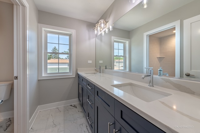 bathroom with toilet, a healthy amount of sunlight, dual vanity, and tile patterned floors