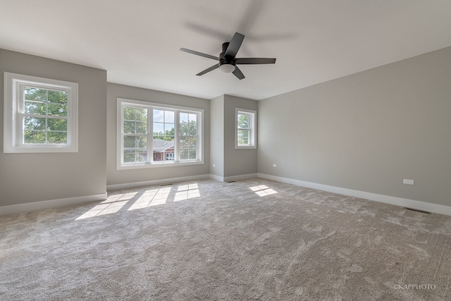 carpeted spare room with ceiling fan