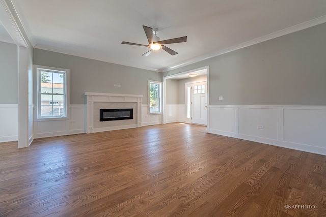 unfurnished living room featuring ceiling fan, hardwood / wood-style flooring, a fireplace, and ornamental molding