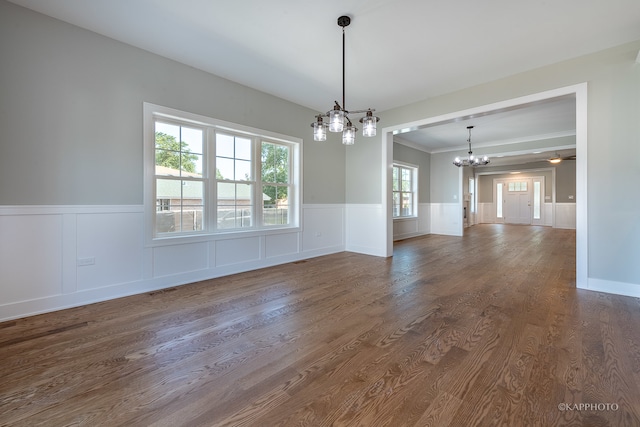 unfurnished room featuring plenty of natural light, dark hardwood / wood-style flooring, and a chandelier