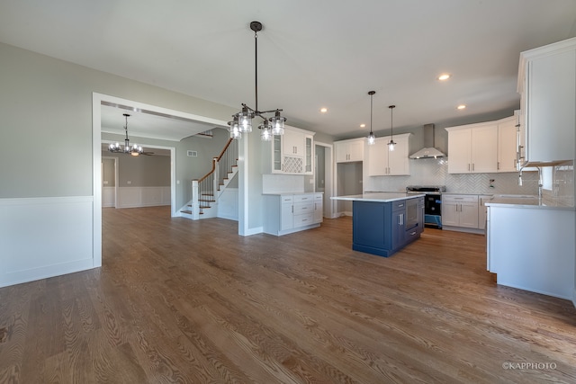 kitchen featuring stove, dark hardwood / wood-style flooring, an inviting chandelier, and wall chimney range hood