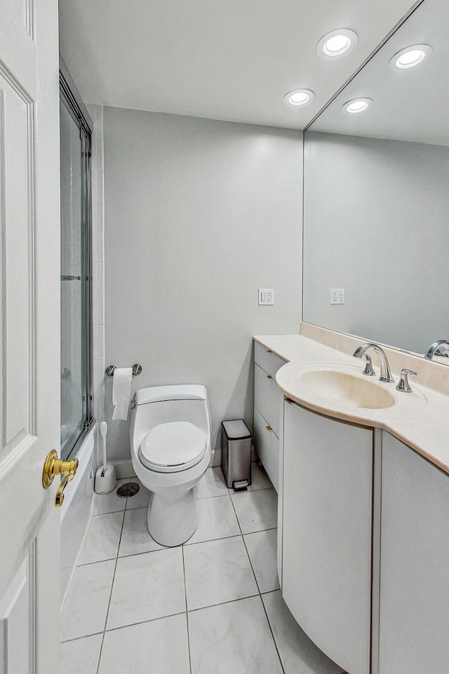 full bathroom featuring tile patterned floors, toilet, bath / shower combo with glass door, and vanity