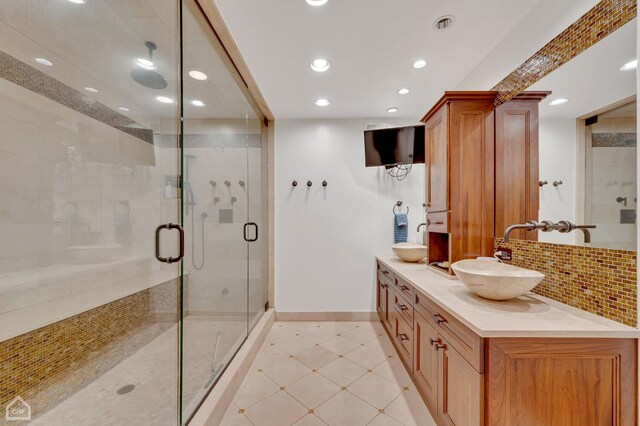 bathroom featuring tile patterned flooring, an enclosed shower, decorative backsplash, and vanity