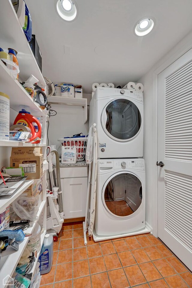 laundry room with stacked washing maching and dryer and cabinets