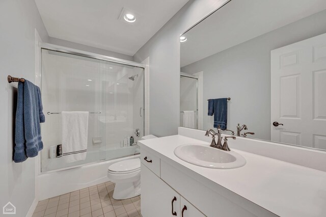 full bathroom featuring tile patterned flooring, toilet, combined bath / shower with glass door, and vanity