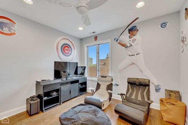 living room featuring hardwood / wood-style floors and ceiling fan