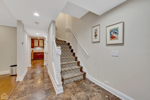 stairway featuring sink and wood-type flooring