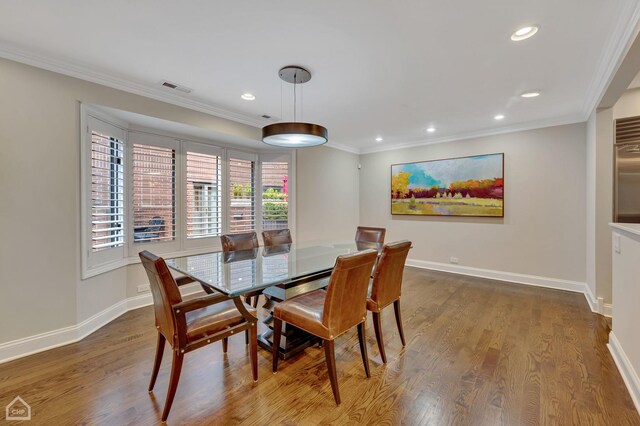 dining area with crown molding and hardwood / wood-style flooring