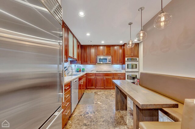 kitchen with decorative light fixtures, backsplash, appliances with stainless steel finishes, sink, and wooden counters