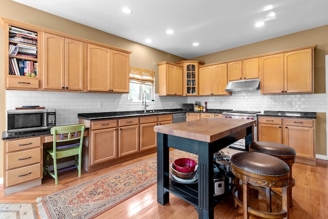 kitchen featuring sink, stainless steel appliances, light hardwood / wood-style floors, a kitchen island, and light brown cabinets