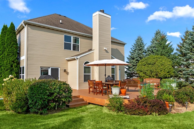 rear view of house featuring a yard and a deck