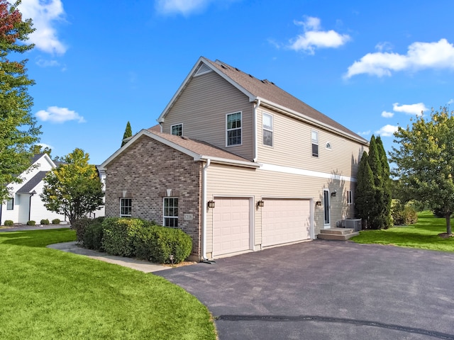 view of home's exterior featuring a garage, a yard, and central AC unit