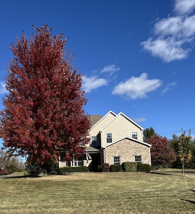 view of side of home with a yard