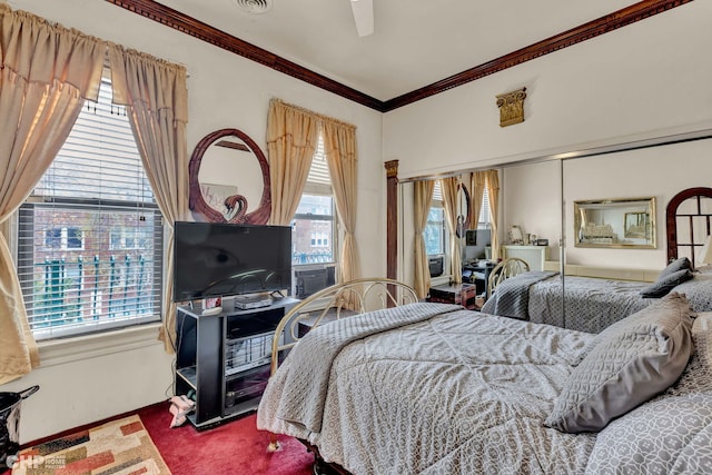 bedroom featuring multiple windows, ceiling fan, crown molding, and carpet floors