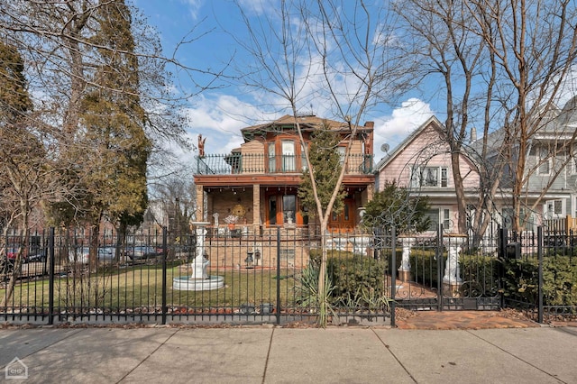 view of front facade featuring a balcony and a front yard