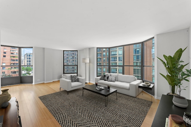 living room with a wealth of natural light, expansive windows, and light hardwood / wood-style floors