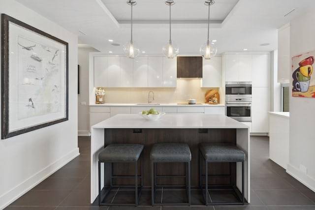 1040 N Lake Shore Dr Unit 9A, Chicago, IL 60611 - kitchen with modern cabinets, a sink, white cabinetry, a breakfast bar, and dark tile patterned flooring