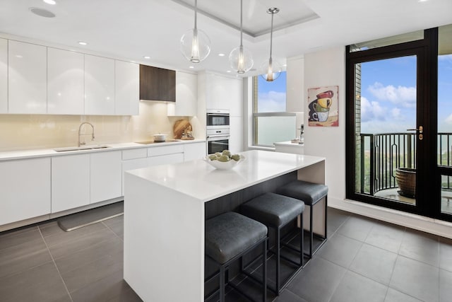 1040 N Lake Shore Dr Unit 9A, Chicago, IL 60611 - kitchen featuring a sink, a breakfast bar, black electric stovetop, white cabinets, and recessed lighting
