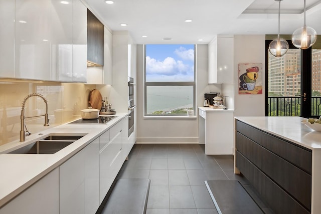 1040 N Lake Shore Dr Unit 9A, Chicago, IL 60611 - kitchen featuring modern cabinets, a sink, white cabinetry, black electric stovetop, and baseboards