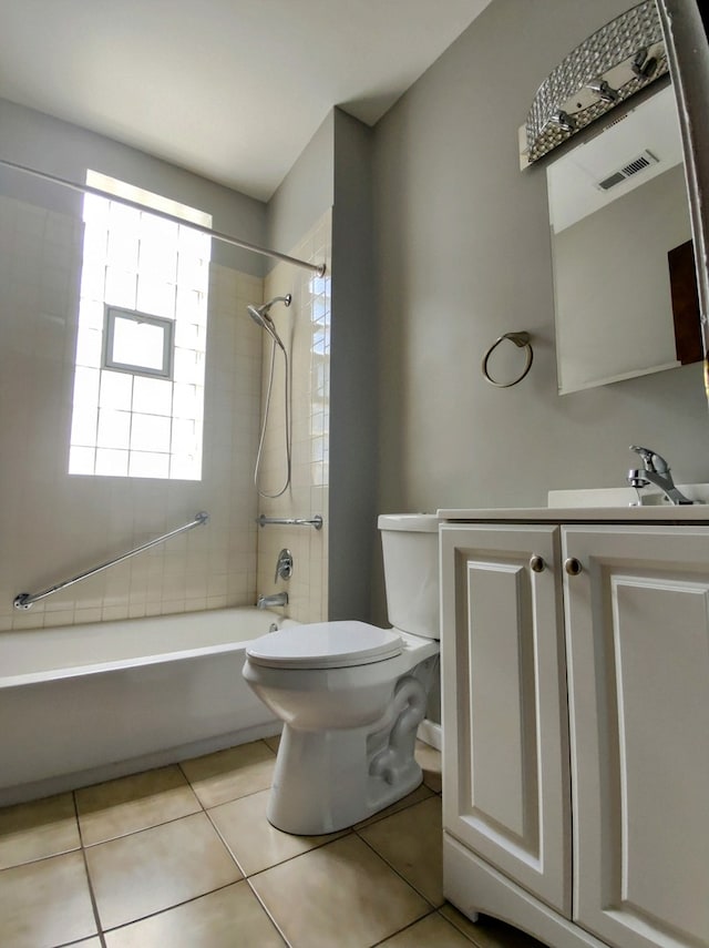 full bathroom featuring tile patterned floors, tiled shower / bath combo, toilet, and vanity