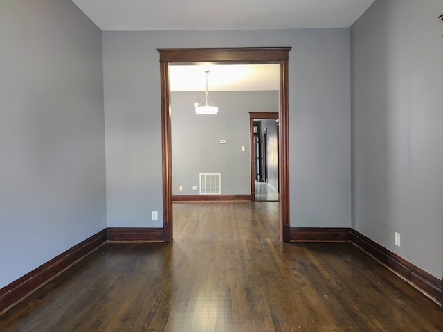 empty room with dark hardwood / wood-style flooring