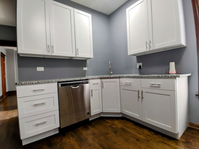 kitchen with light stone countertops, white cabinetry, dark wood-type flooring, and stainless steel dishwasher