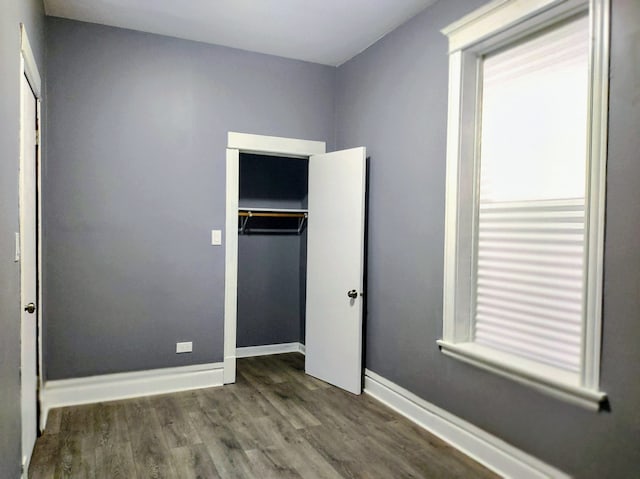 unfurnished bedroom featuring dark hardwood / wood-style floors and a closet