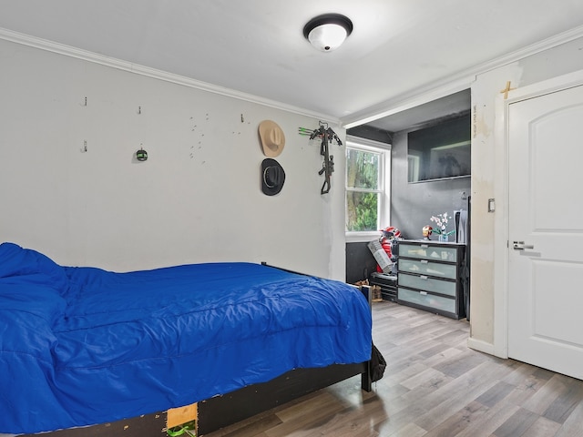 bedroom with ornamental molding and hardwood / wood-style floors