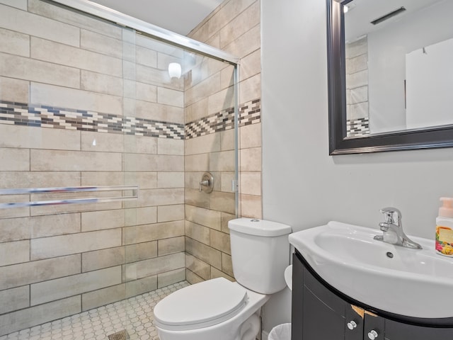 bathroom featuring vanity, toilet, tile patterned flooring, and a shower with door