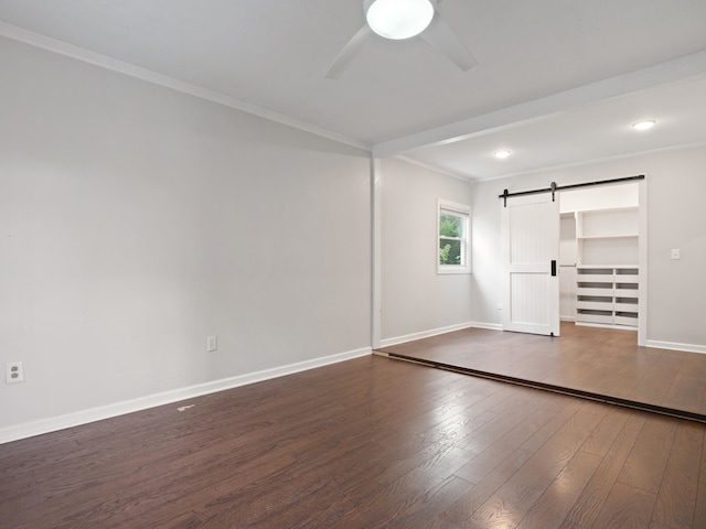 unfurnished bedroom with a barn door, a closet, ceiling fan, and dark hardwood / wood-style floors