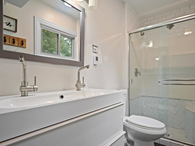 bathroom with vanity, toilet, and a shower with shower door