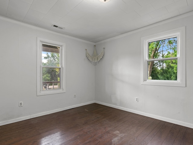 spare room featuring crown molding, plenty of natural light, and dark hardwood / wood-style floors