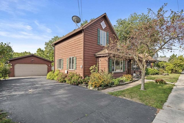 view of side of home with a garage, an outbuilding, and a lawn