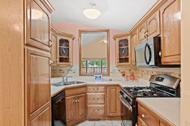 kitchen featuring backsplash, light tile patterned floors, vaulted ceiling, appliances with stainless steel finishes, and sink