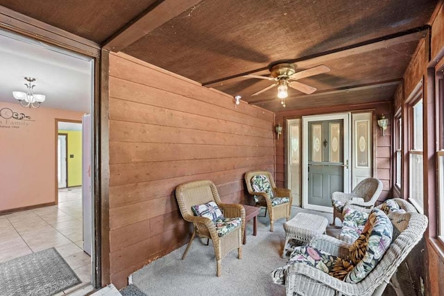 sunroom featuring ceiling fan with notable chandelier and wooden ceiling