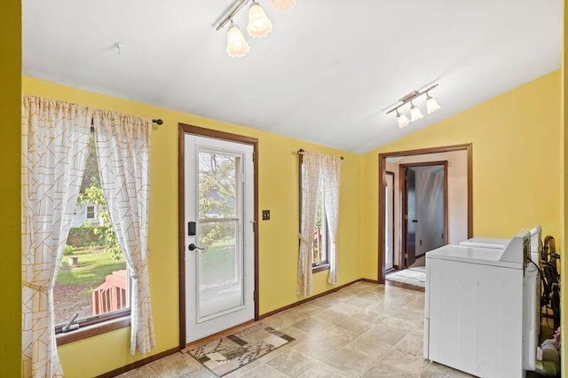 entryway featuring washer / dryer, vaulted ceiling, and rail lighting