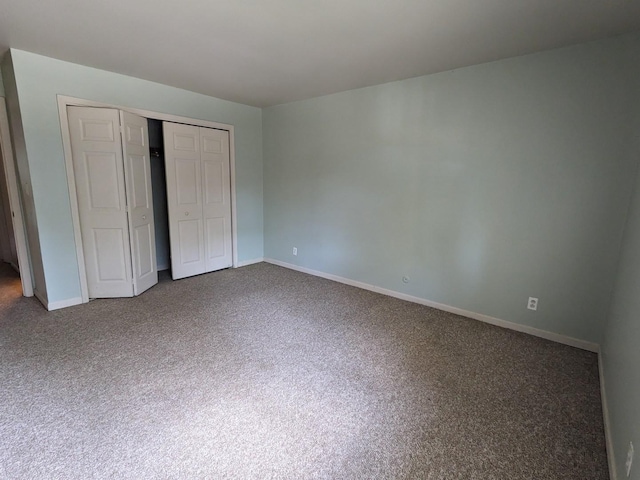 unfurnished bedroom featuring a closet, baseboards, and carpet flooring