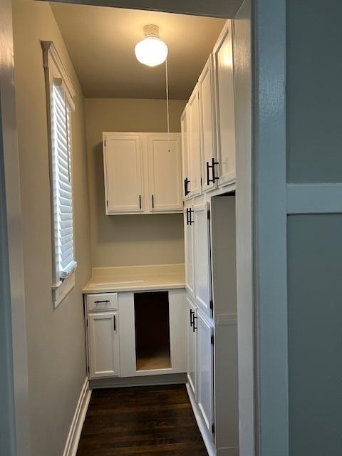 interior space with dark wood finished floors and baseboards