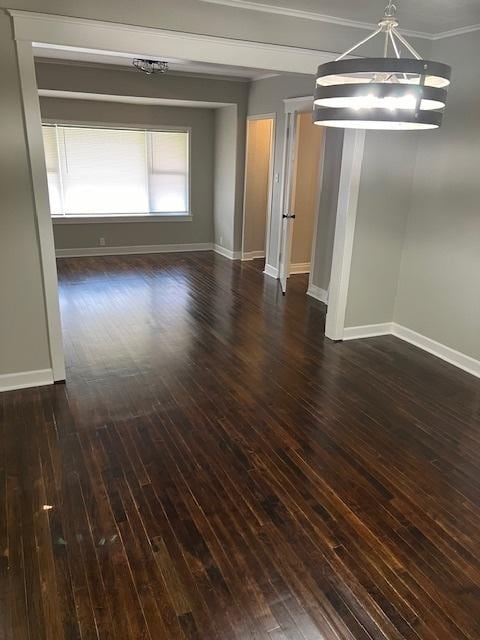 unfurnished dining area with crown molding, baseboards, and dark wood-type flooring